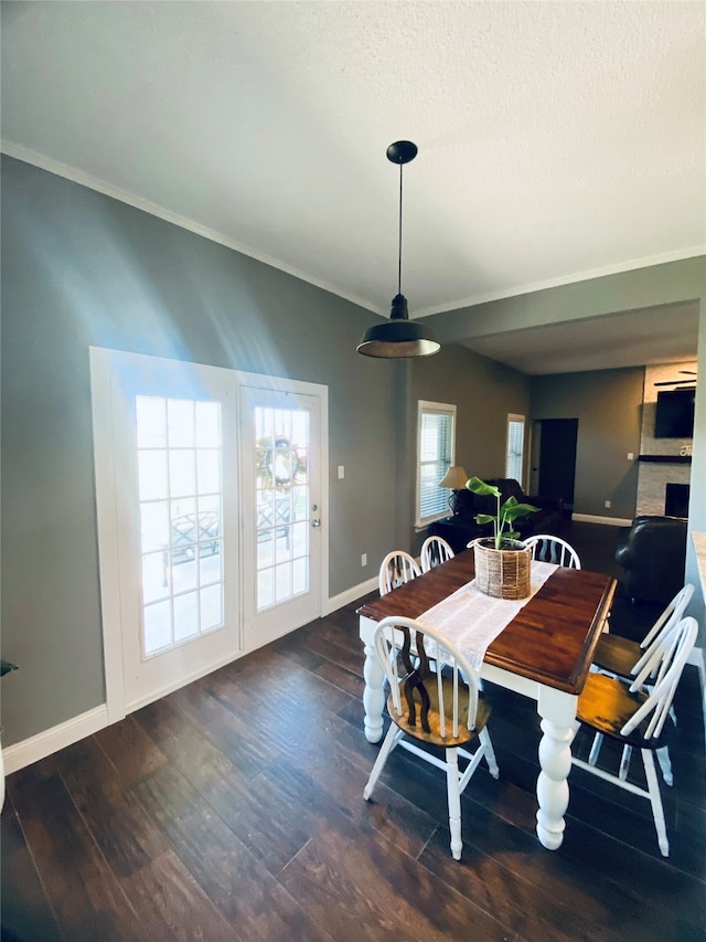 dining space featuring a textured ceiling, dark hardwood / wood-style flooring, and crown molding