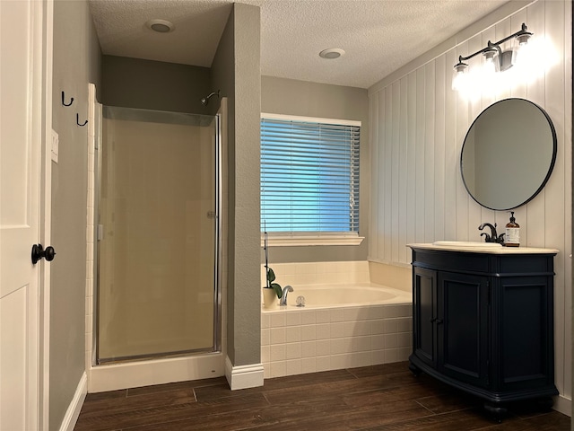 bathroom with vanity, plus walk in shower, wood-type flooring, and a textured ceiling