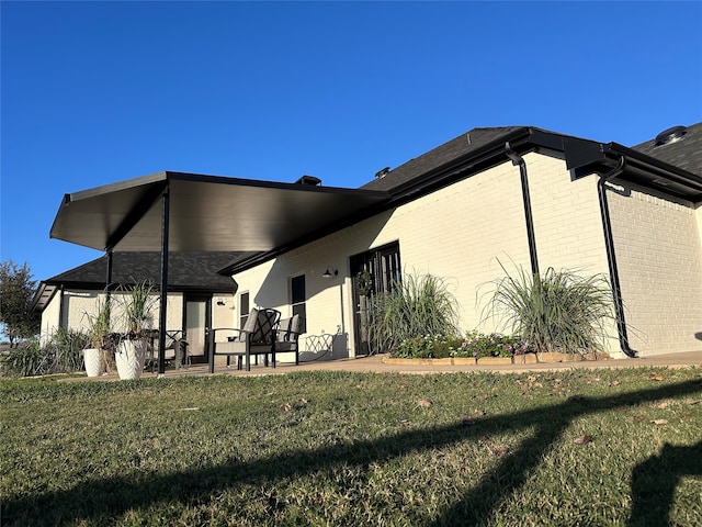 rear view of house featuring a yard and a patio