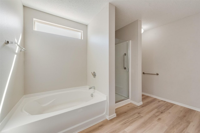 1200 Scenic Hills Dr, Mckinney, TX 75071 - bathroom with a garden tub, a shower stall, a textured ceiling, wood finished floors, and baseboards