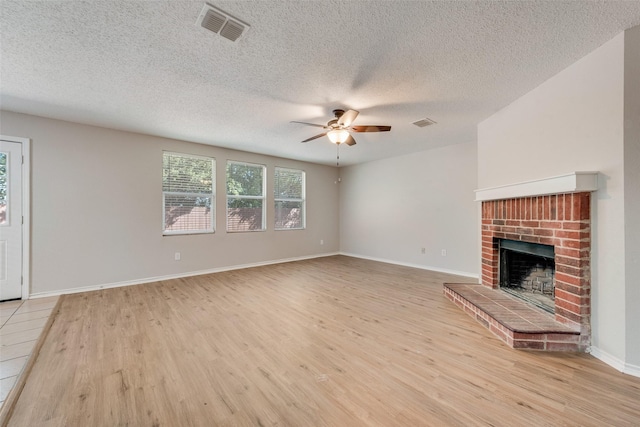 1200 Scenic Hills Dr, Mckinney, TX 75071 - unfurnished living room with light wood-style floors, visible vents, a ceiling fan, and a brick fireplace