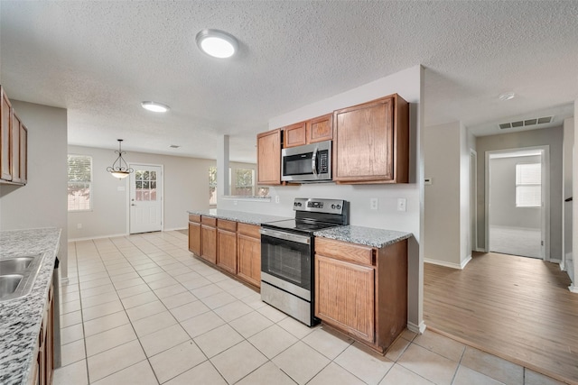 1200 Scenic Hills Dr, Mckinney, TX 75071 - kitchen with a healthy amount of sunlight, light tile patterned floors, visible vents, and appliances with stainless steel finishes
