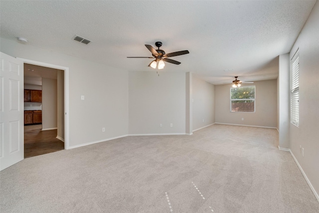 1200 Scenic Hills Dr, Mckinney, TX 75071 - unfurnished room with light carpet, visible vents, a textured ceiling, and a ceiling fan