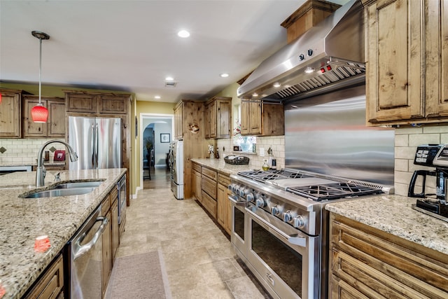 kitchen with pendant lighting, sink, appliances with stainless steel finishes, light stone counters, and ventilation hood