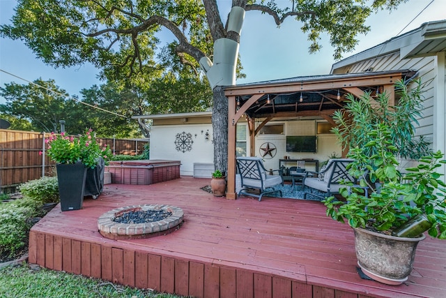 wooden terrace featuring a gazebo and an outdoor living space with a fire pit