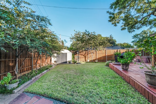 view of yard featuring a deck and a storage unit