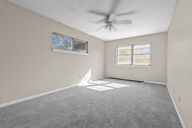 carpeted spare room with ceiling fan and a textured ceiling