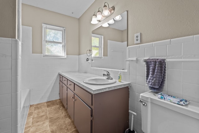 full bathroom featuring tile walls, vanity, independent shower and bath, toilet, and tile patterned floors