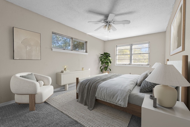 carpeted bedroom with ceiling fan and a textured ceiling