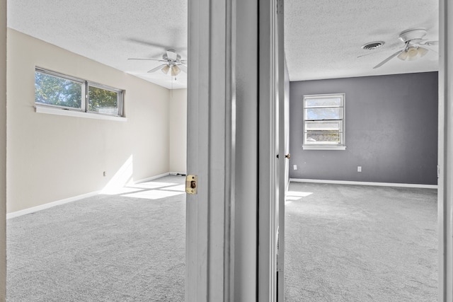 carpeted empty room with a textured ceiling and ceiling fan