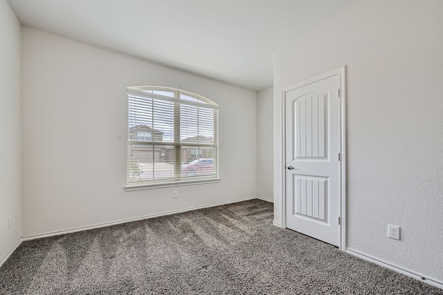 unfurnished bedroom with dark colored carpet