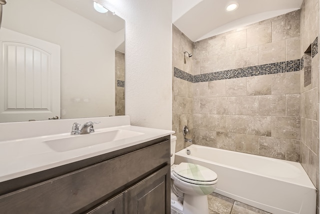 full bathroom featuring tile patterned flooring, tiled shower / bath, vanity, and toilet