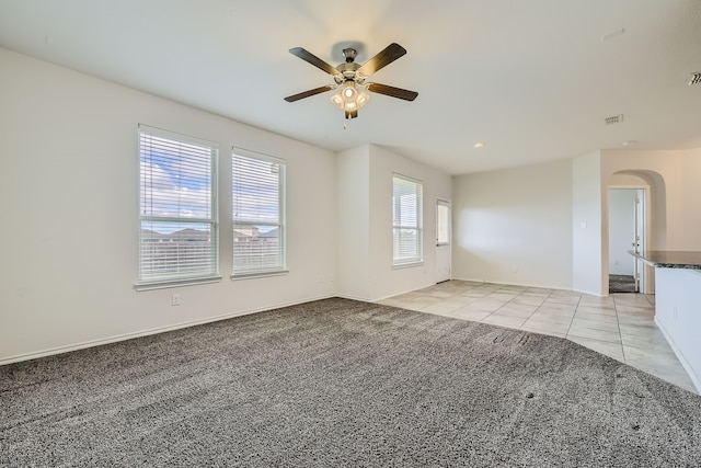 unfurnished living room with light carpet and ceiling fan