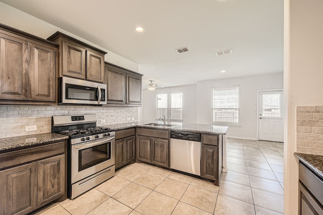 kitchen featuring appliances with stainless steel finishes, kitchen peninsula, ceiling fan, a healthy amount of sunlight, and sink