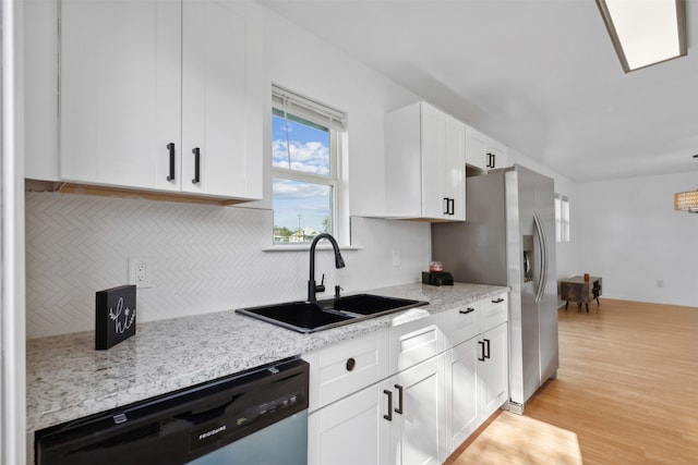 kitchen featuring light stone countertops, appliances with stainless steel finishes, sink, white cabinets, and light hardwood / wood-style floors