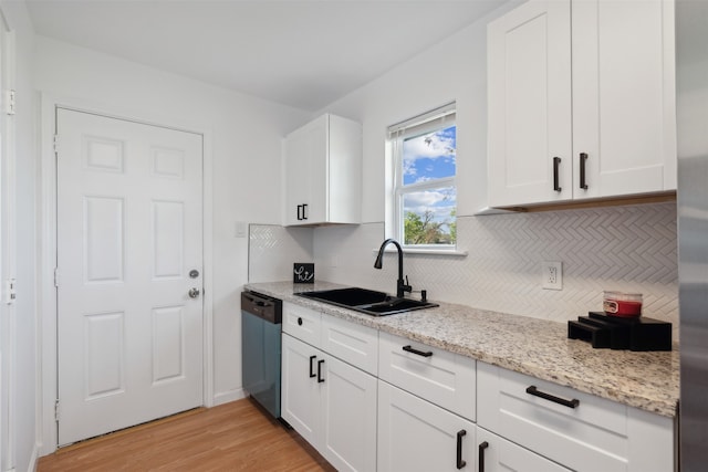 kitchen featuring light stone counters, sink, dishwasher, white cabinets, and light hardwood / wood-style floors