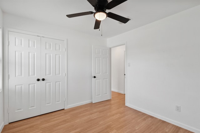 unfurnished bedroom featuring a closet, light hardwood / wood-style floors, and ceiling fan