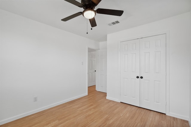 unfurnished bedroom featuring a closet, light hardwood / wood-style flooring, and ceiling fan