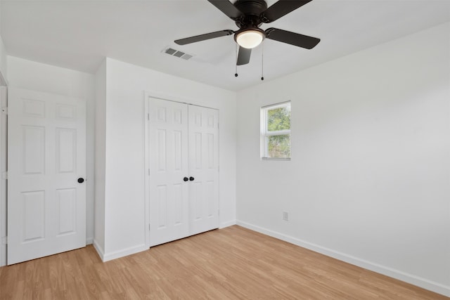 unfurnished bedroom with a closet, light hardwood / wood-style floors, and ceiling fan