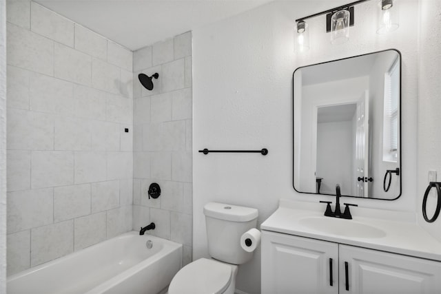 full bathroom with vanity, tiled shower / bath combo, and toilet