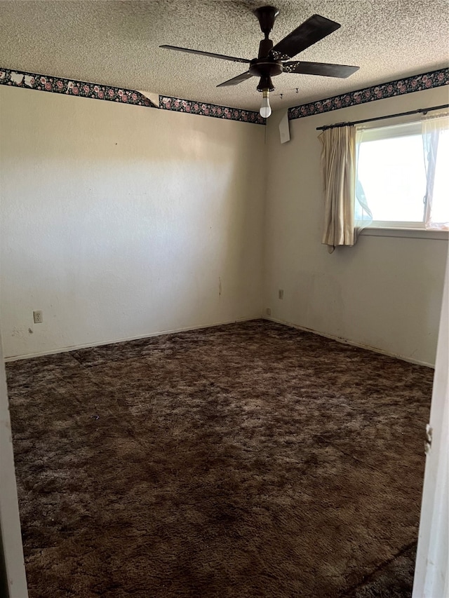 empty room featuring ceiling fan, a textured ceiling, and carpet flooring