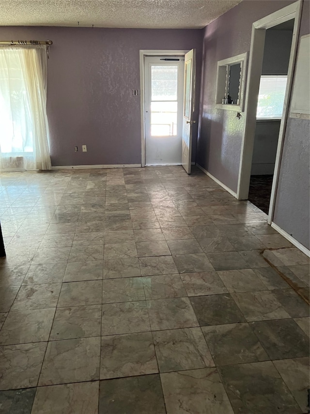 unfurnished room with a textured ceiling