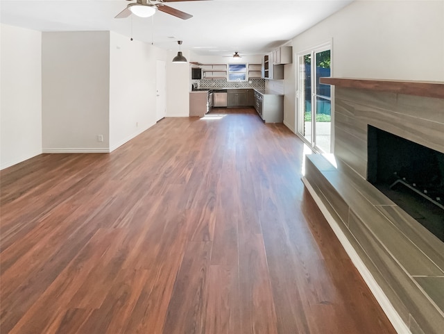 unfurnished living room with ceiling fan, dark hardwood / wood-style flooring, and a high end fireplace