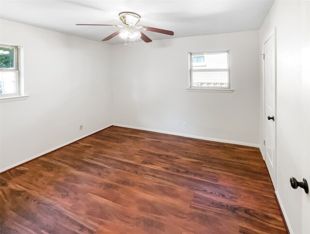 empty room featuring ceiling fan, dark hardwood / wood-style floors, and a healthy amount of sunlight