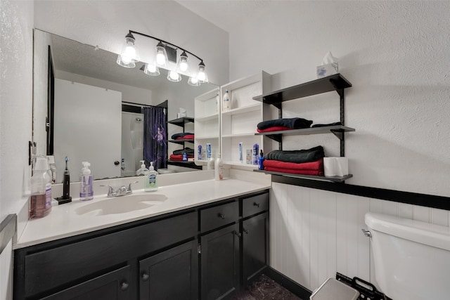 bathroom featuring vanity, toilet, and curtained shower