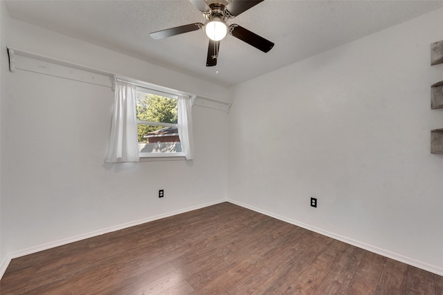 spare room featuring a textured ceiling, dark wood-type flooring, and ceiling fan