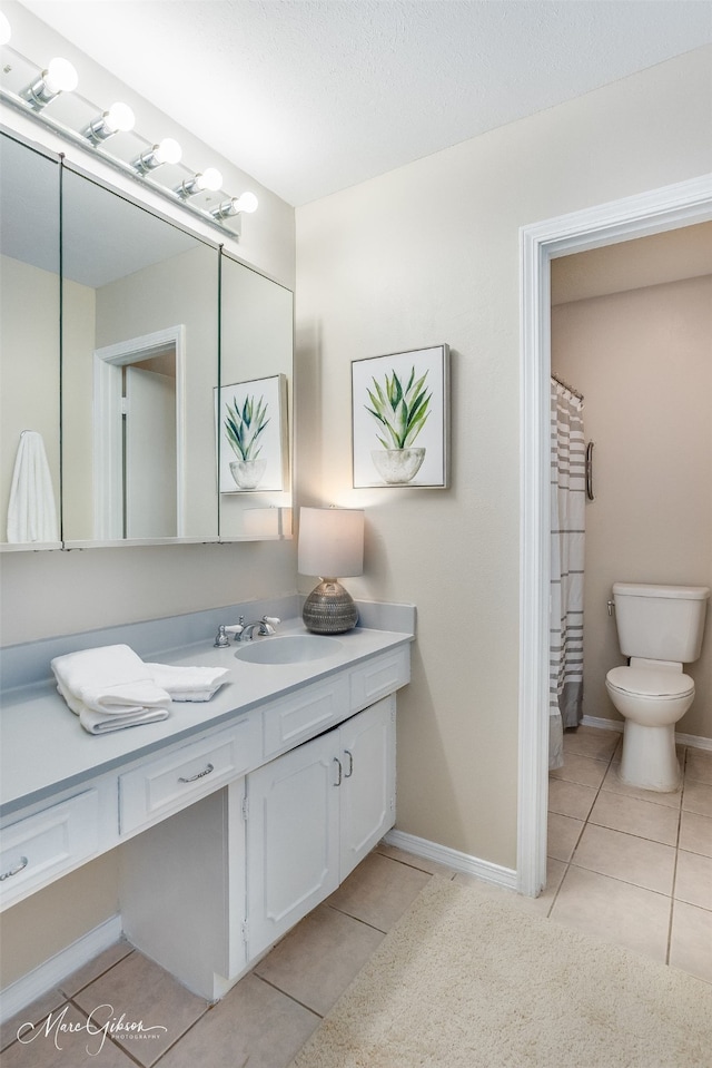 bathroom with a shower with curtain, vanity, toilet, and tile patterned floors