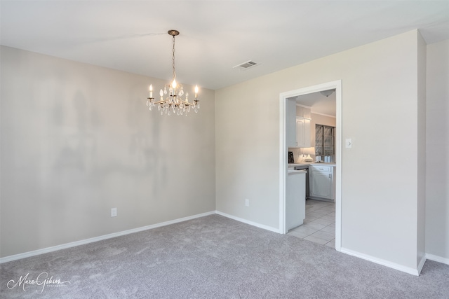 carpeted spare room featuring a chandelier