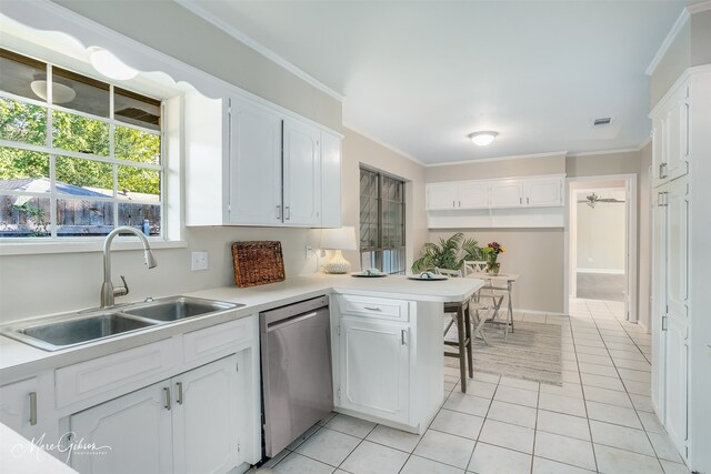 kitchen featuring white cabinets, stainless steel dishwasher, kitchen peninsula, and sink