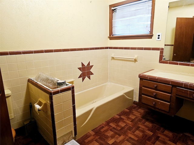 bathroom with vanity, parquet floors, a bath, and tile walls