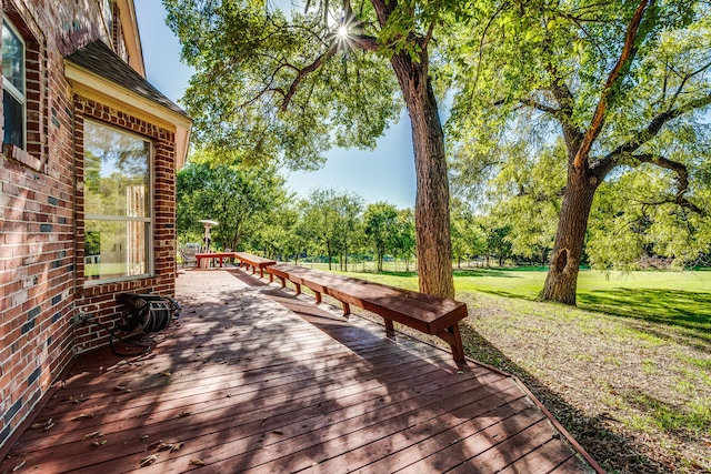 wooden deck featuring a lawn