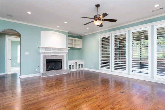 living room with ornate columns, dark wood-type flooring, crown molding, and a fireplace