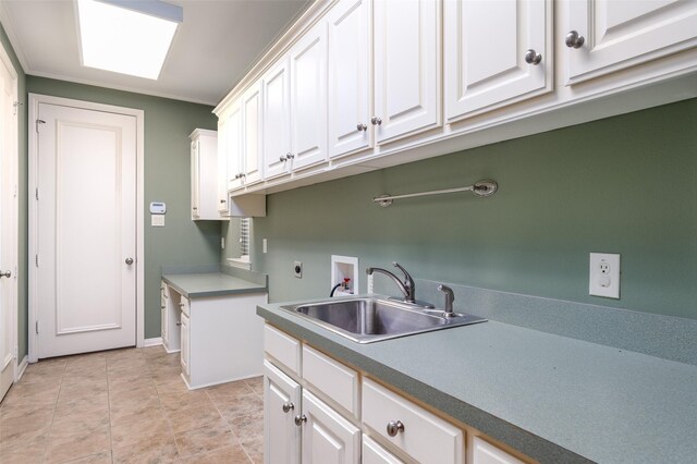 laundry area with washing machine and dryer, cabinets, sink, ornamental molding, and light tile patterned floors