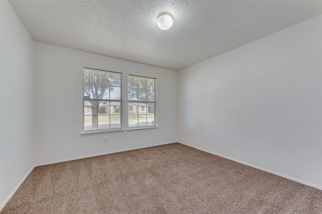 empty room with a textured ceiling and carpet