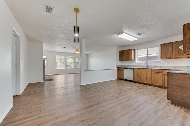 kitchen featuring light wood-type flooring, a textured ceiling, ceiling fan, decorative light fixtures, and stainless steel dishwasher