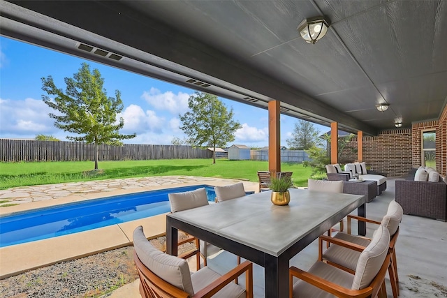 view of patio with a fenced in pool, outdoor lounge area, and a storage unit