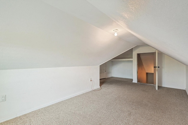 bonus room featuring lofted ceiling, carpet flooring, and a textured ceiling