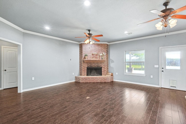 unfurnished living room featuring crown molding, a brick fireplace, a textured ceiling, dark hardwood / wood-style floors, and ceiling fan