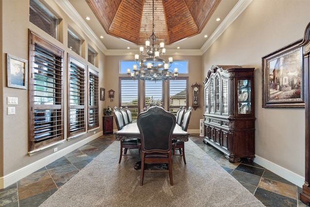 dining room featuring a notable chandelier, a towering ceiling, a healthy amount of sunlight, and crown molding