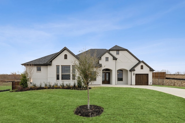 french provincial home featuring a garage and a front lawn