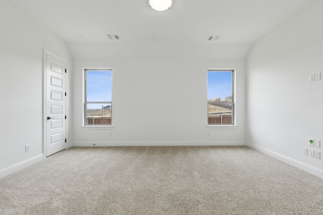 carpeted empty room with lofted ceiling