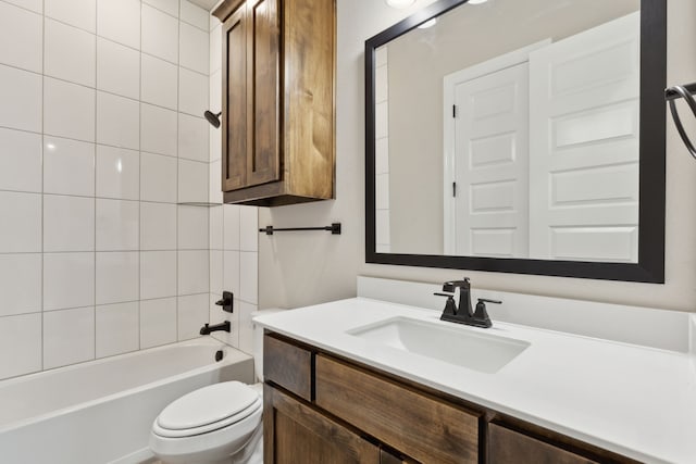 full bathroom featuring vanity, tiled shower / bath combo, and toilet