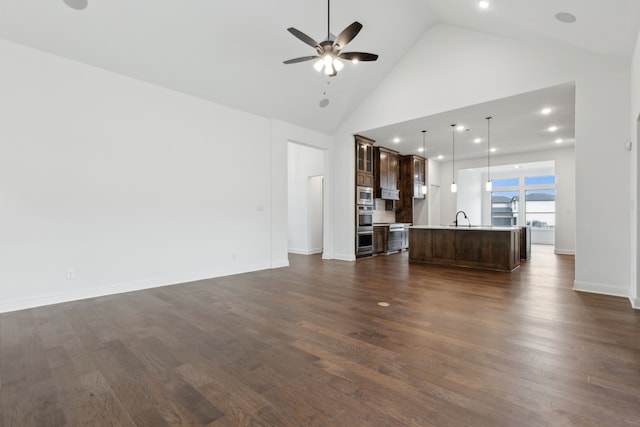 unfurnished living room featuring ceiling fan, sink, high vaulted ceiling, and dark hardwood / wood-style floors