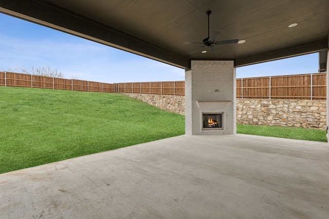 view of patio / terrace with an outdoor brick fireplace and ceiling fan