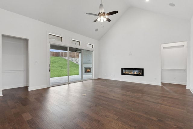 unfurnished living room with a fireplace, high vaulted ceiling, ceiling fan, and dark wood-type flooring