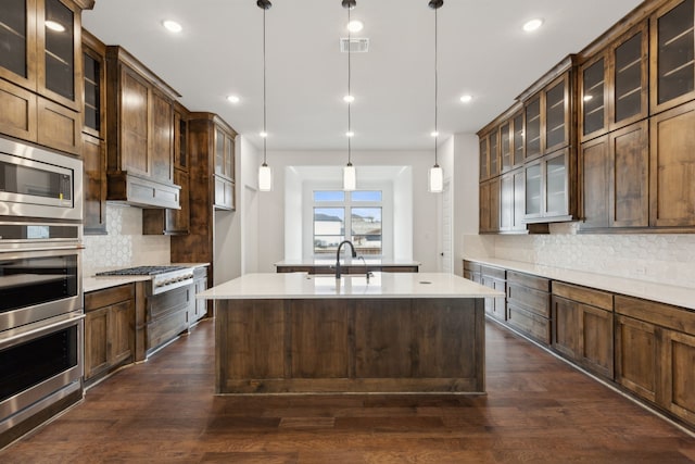 kitchen with backsplash, dark wood-type flooring, sink, and hanging light fixtures